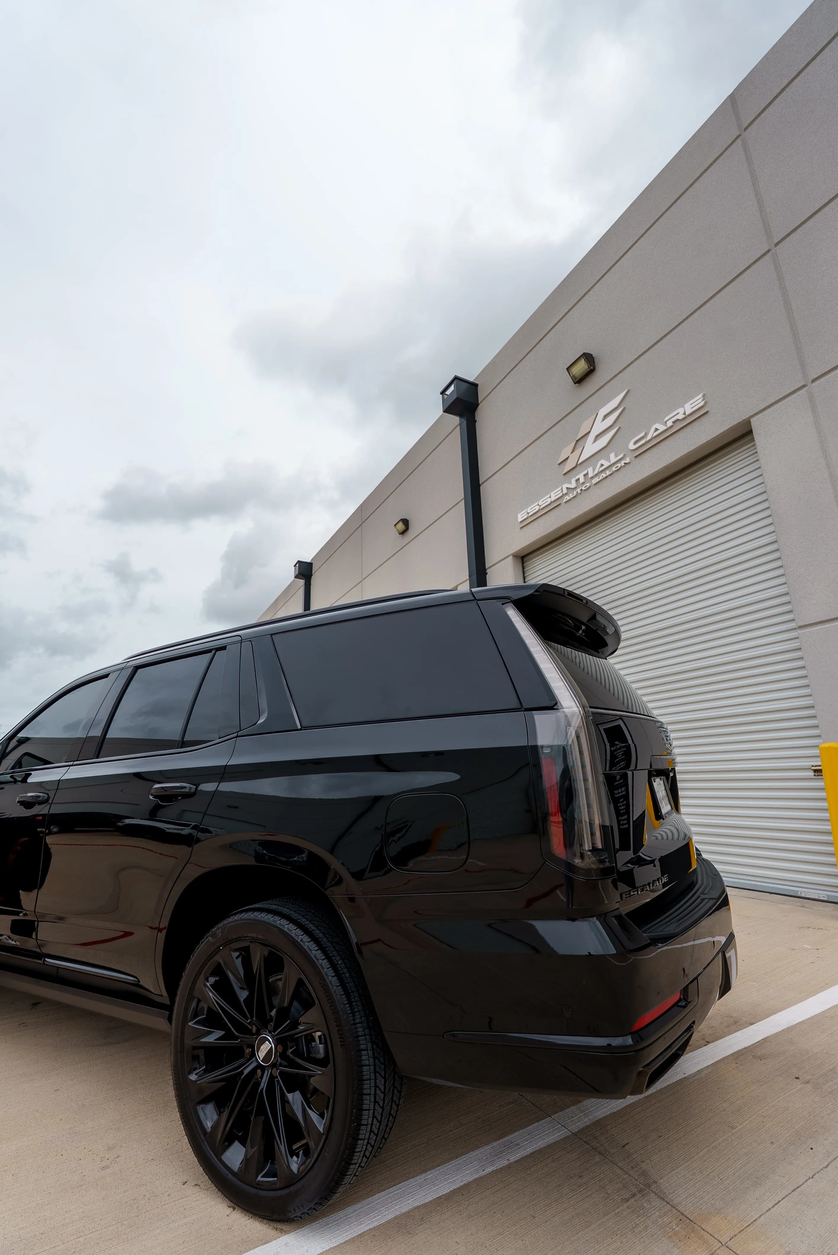 Rear of a blacked-out Cadillac Escalade with tinted windows