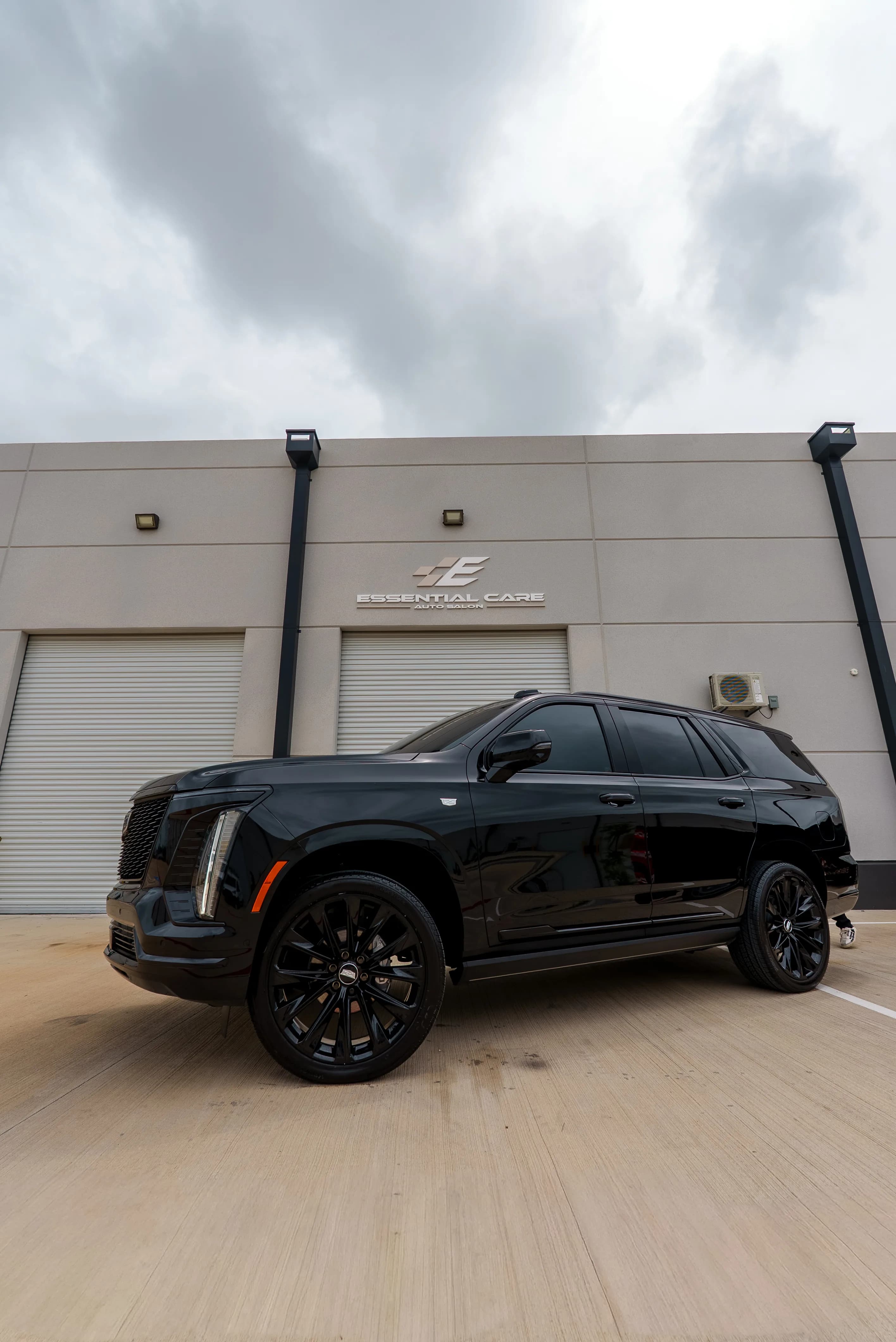 Side profile of a blacked-out Cadillac Escalade with tinted glass