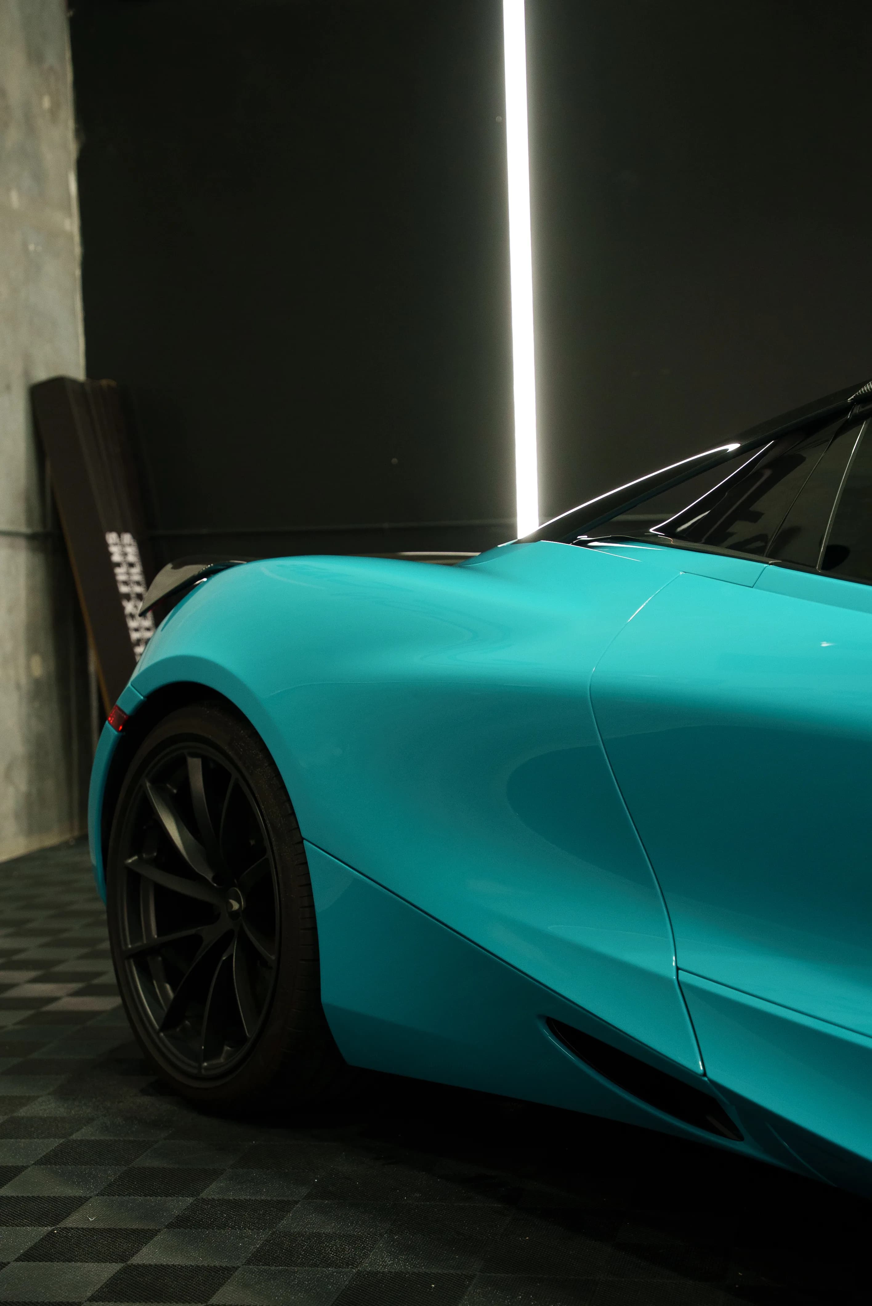 Side profile of a teal color-change wrapped McLaren 720S