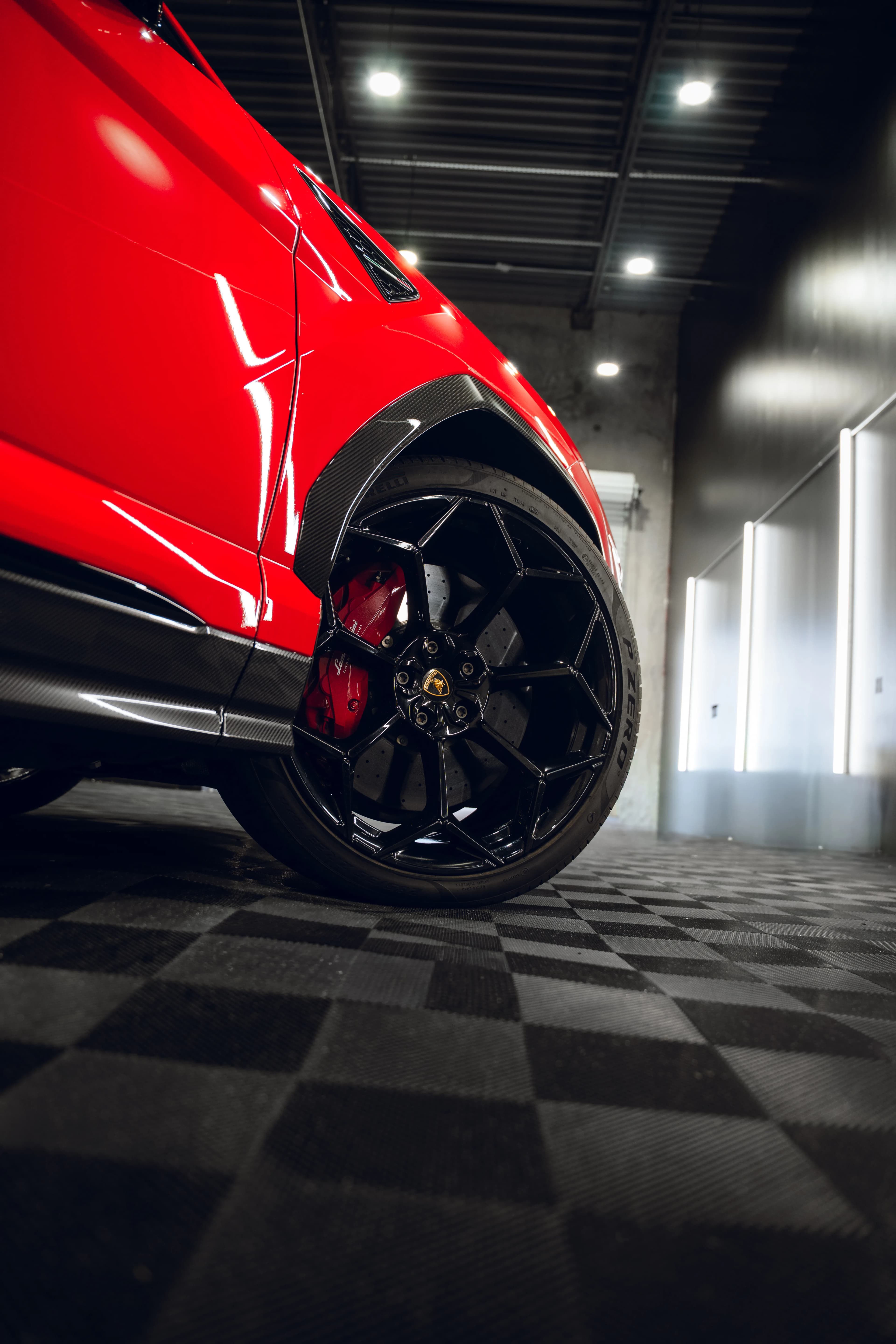 Close-up of custom wheel and brake detail on a red Lamborghini